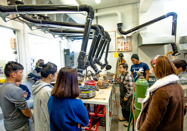 Students and faculty working with the six acetylene soldering stations in the casting area