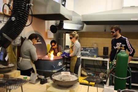 Students and faculty working in the casting area, annealing station, and enameling kiln