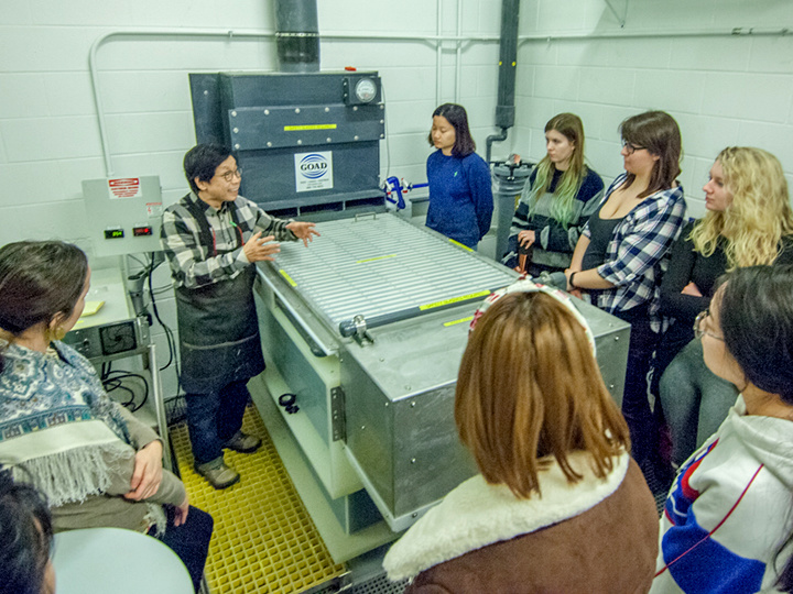 Students and faculty speaking near the 250-gallon electroforming tank